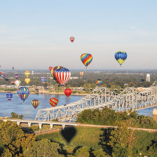 Hot air balloons floating over a bridge during Mississippi’s Natchez Balloon Festival