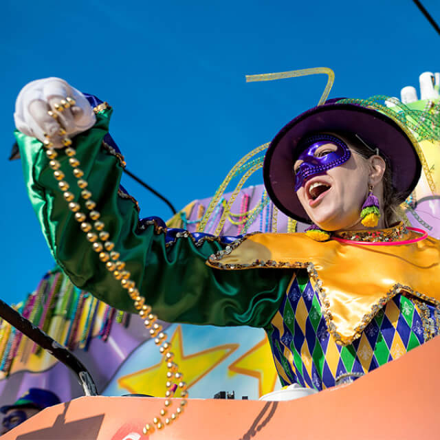 A performer throws beads from a Mardi Gras float in Louisiana