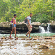 Hikers walk past small waterfalls at Kings River Falls Natural Area in Witter, Arkansas