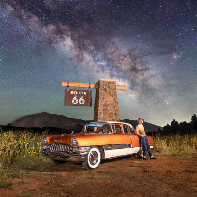 Posing with a classic car beneath a Route 66 sign on a starry night in Flagstaff, Arizona